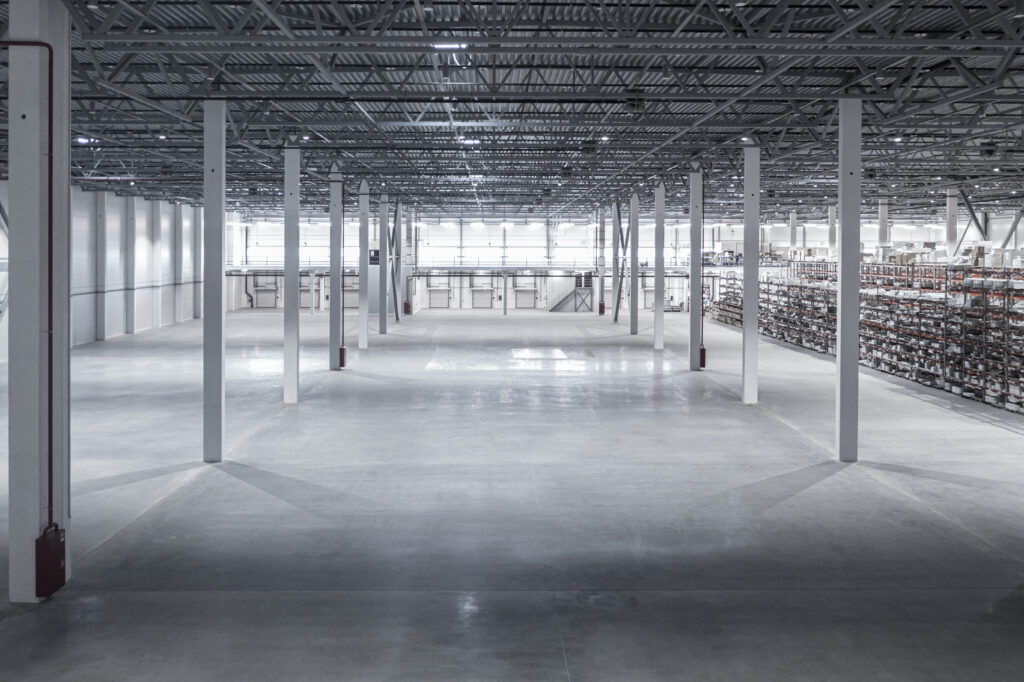 Factory or warehouse or industrial building. Protection with roller door or roller shutter. Modern interior design with concrete floor, steel wall and empty space for industry background.